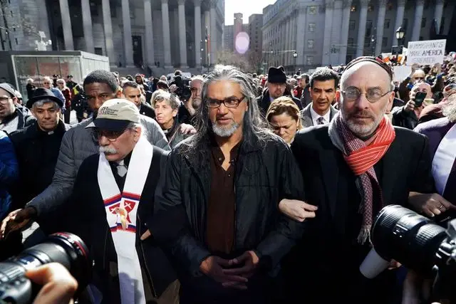 Ravi Ragbir, center, walks with supporters as he arrives for his annual check-in with Immigration and Customs Enforcement in New York.